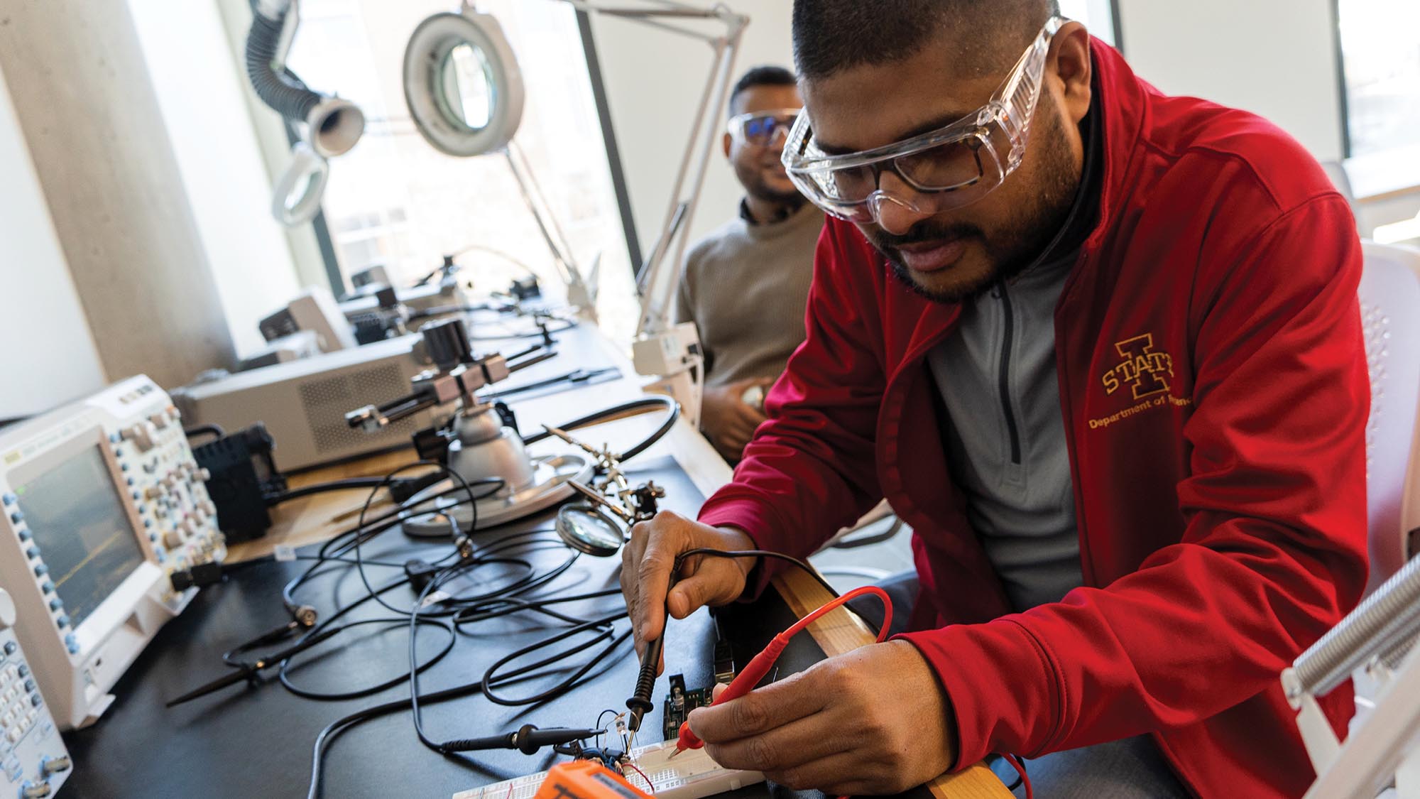 Two students work on electronics in the soldering lab.