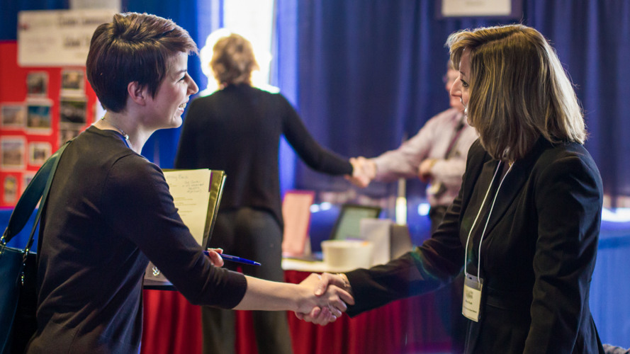 Two women shake hands during a career event