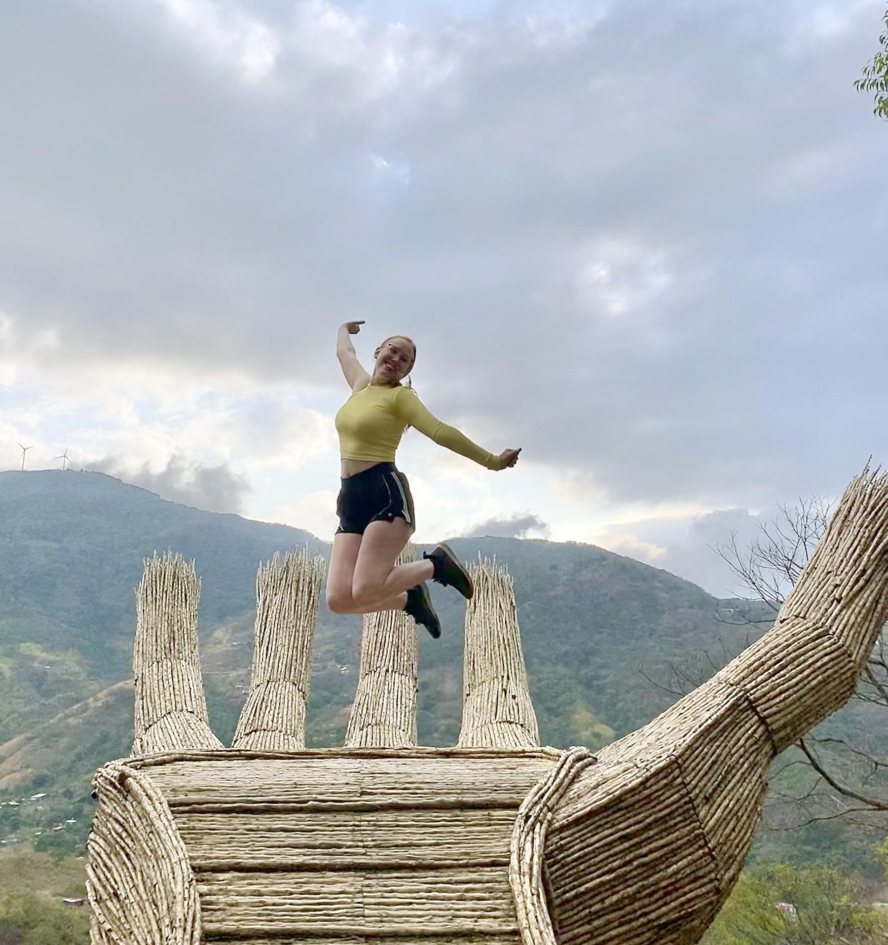 Ashley Hipnar jumps in the air with the Costa Rican mountains in the background