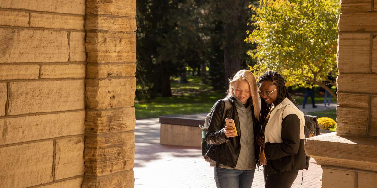 Two students taking a selfie outside