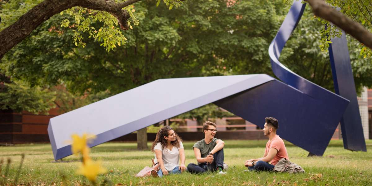 Students sitting on campus under outdoor art