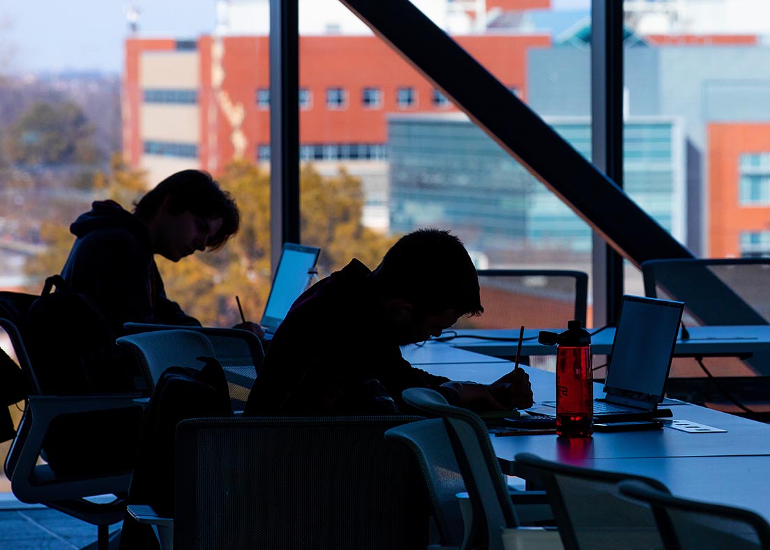 Silhouette of two students studying in the Student Innovation Center