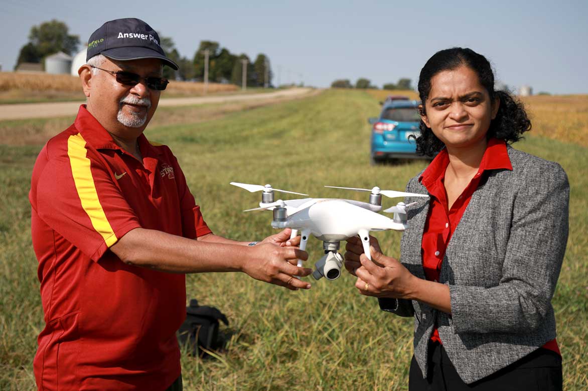 Researchers Sree Nilikanta and Priyanka Jayashankar pose in a rural area with a drone