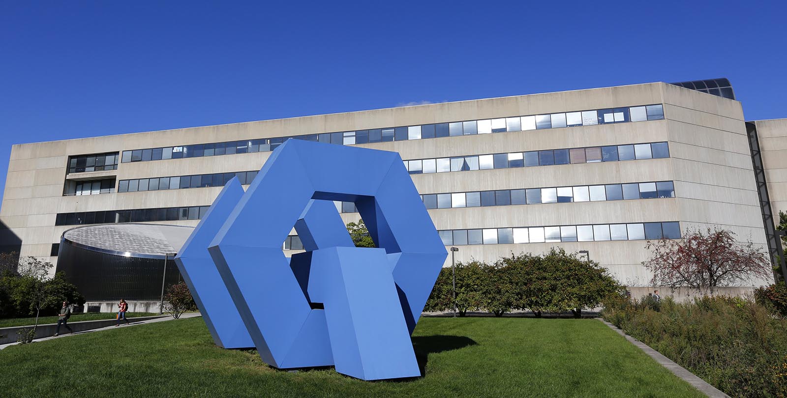 Sunny view of the College of Design building and the blue sculpture in front of it