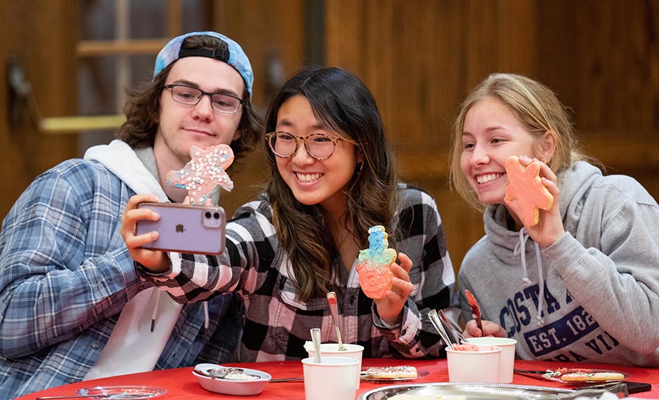 Three students take a selfie with their decorated cookies