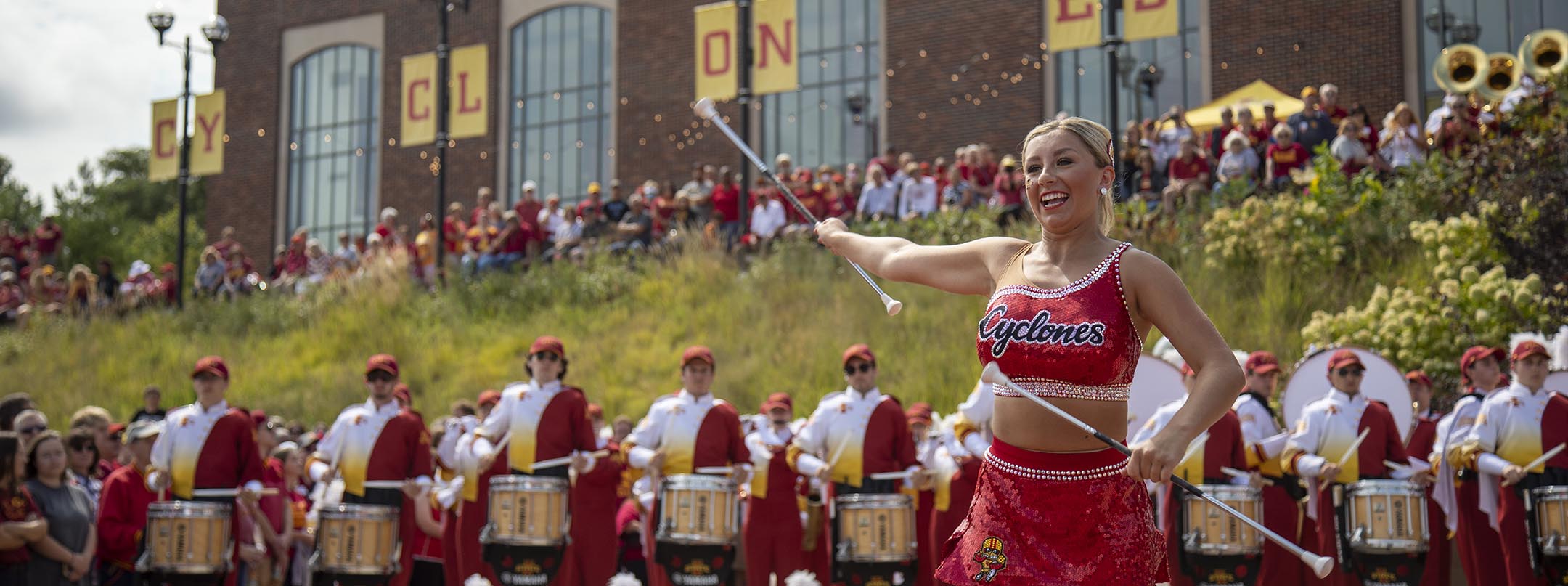 The marching band and twirler perform during a pregame pep rally outside the Alumni building