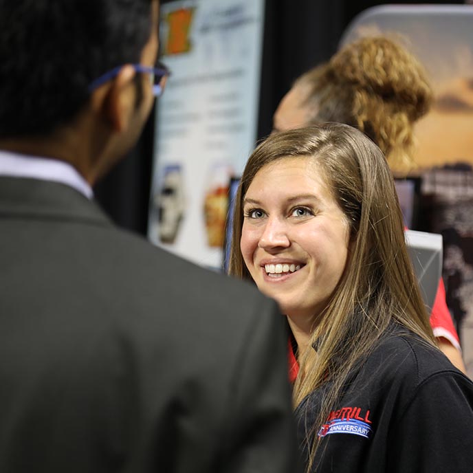 A recruiter talks with a student at the business career fair