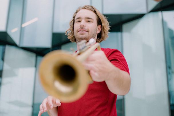 A student poses with his trumpet