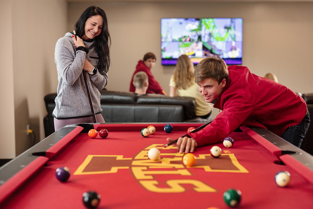 Students play pool in the Geoffroy Hall residence hall
