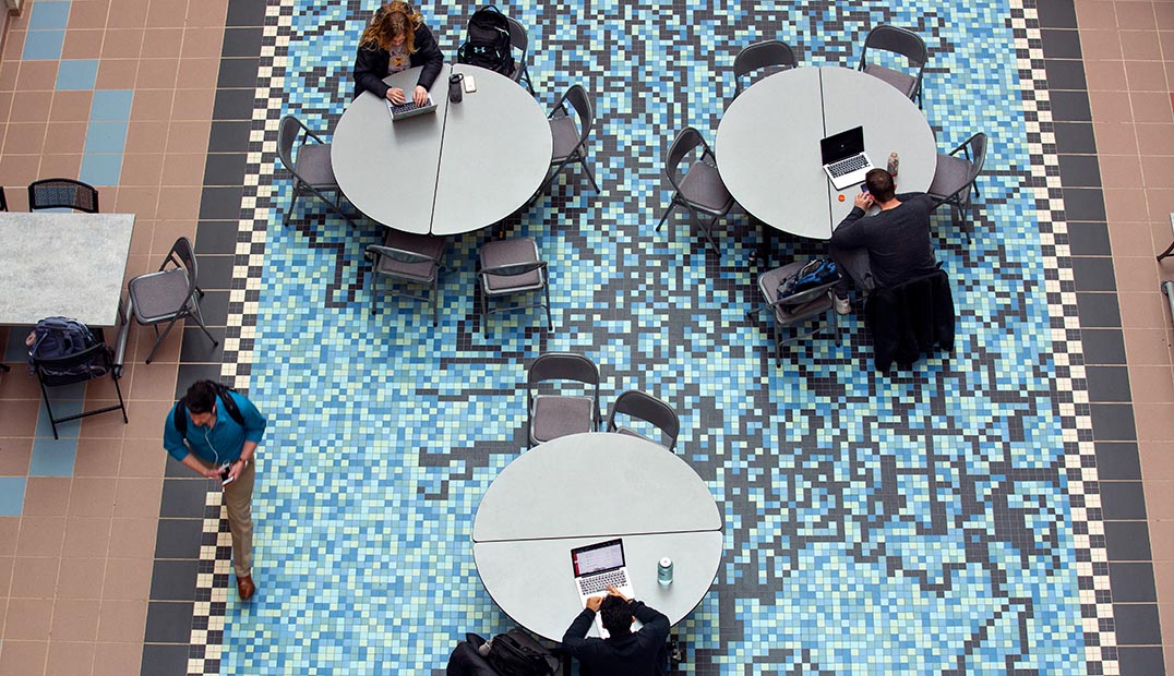 Overhead view of students studying at tables in the Molecular Biology Building lobby