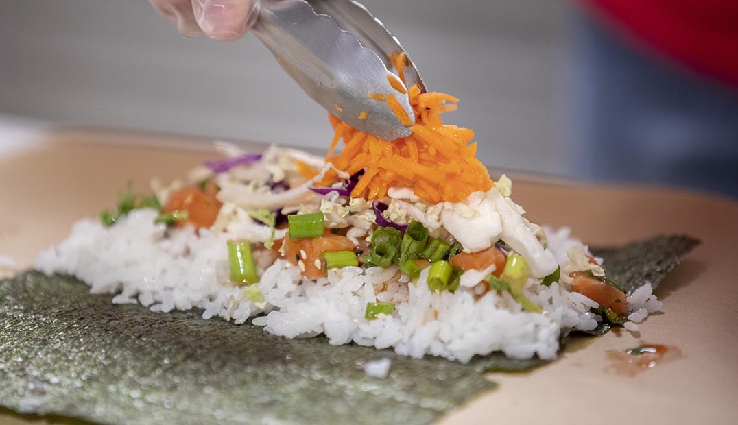 Closeup of dining personnel making sushi