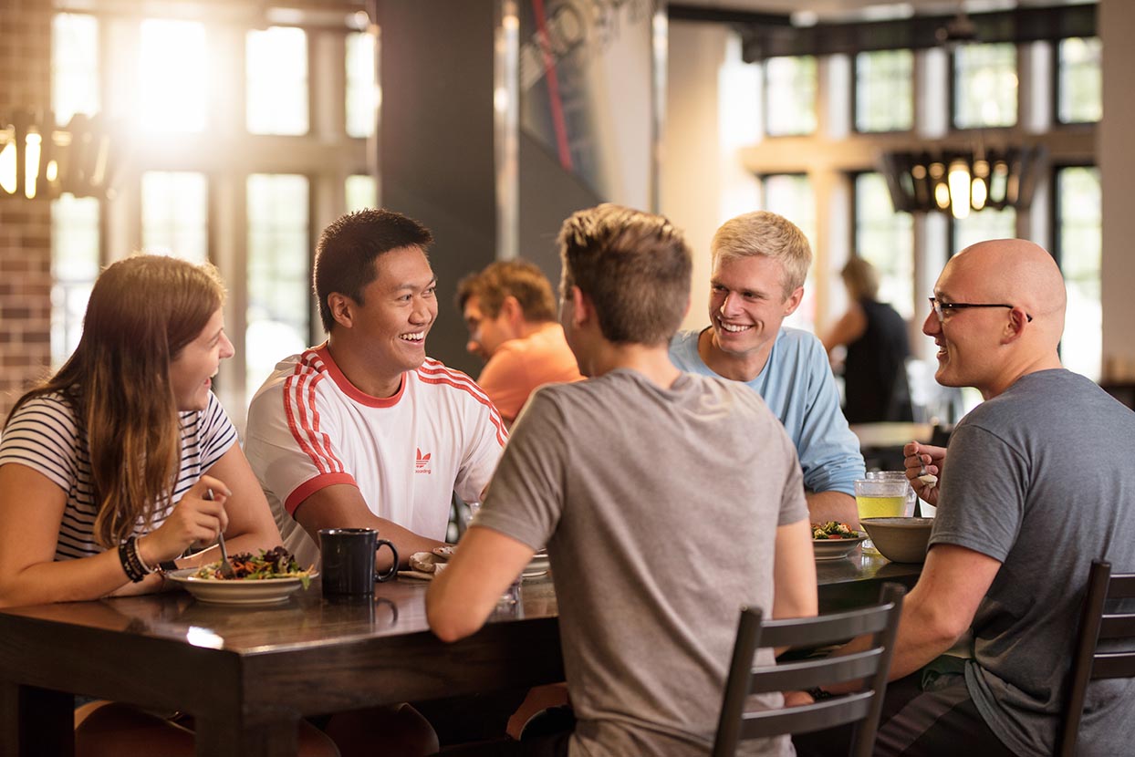 Five people enjoy a meal in a dining center