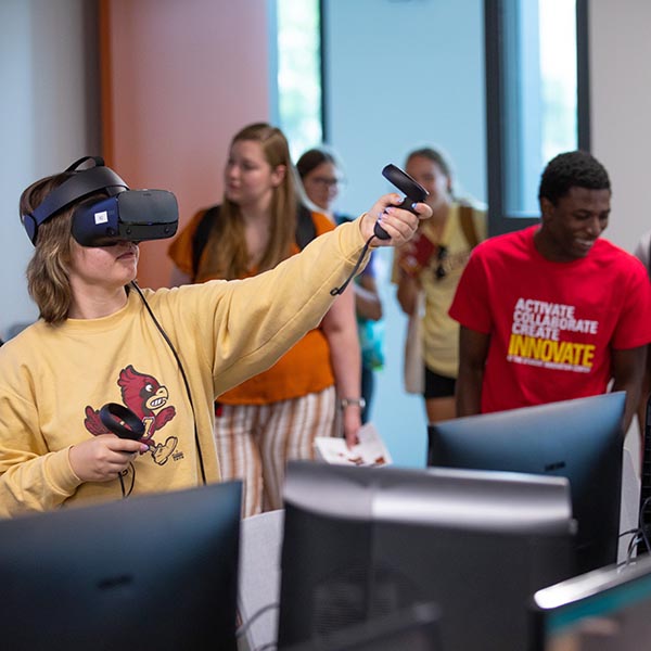 A student using virtual reality goggles and controllers.