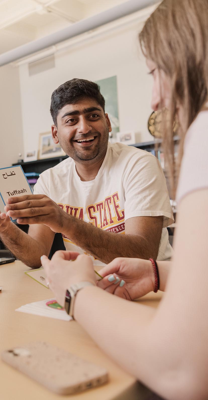 Two students talk as they study together at a table.