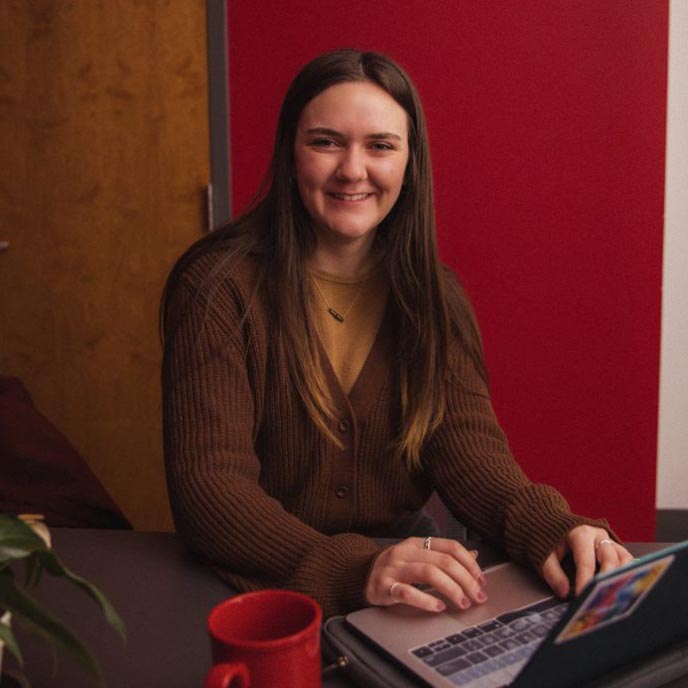Senior Dana Thacker seated at a desk with her laptop.