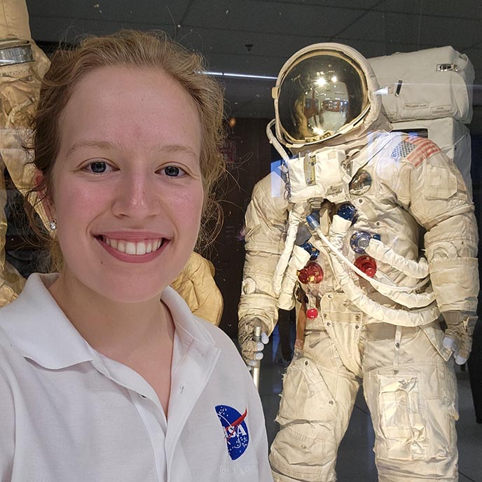 Sarah Stewart poses with a NASA spacesuit .