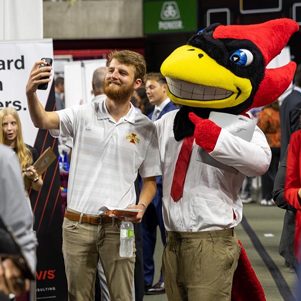 A student poses with Cy for a selfie.