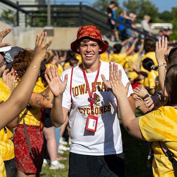 A new student walks through a welcome tunnel of high-fives.