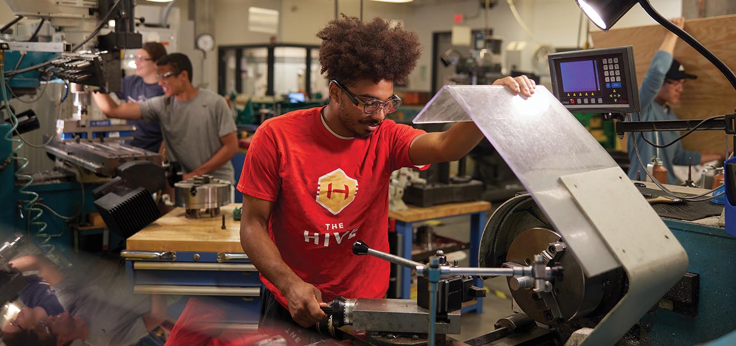 An engineering student works on equipment in the lab.