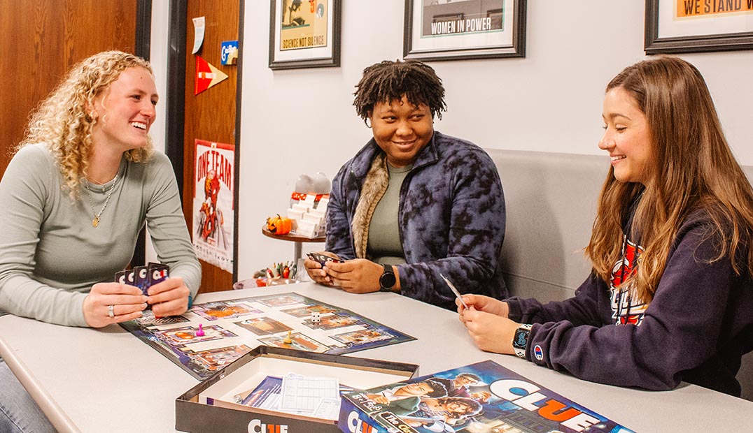 Three students play Clue in the WiSE office.