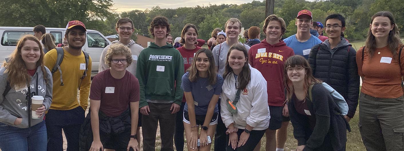 A group of Honors students pose at an outdoor retreat.