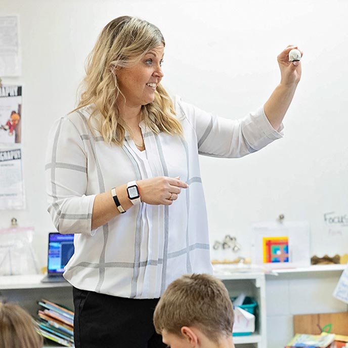 Carrie Hillman talks with young students during class.