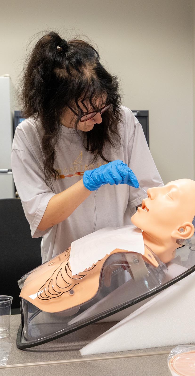 A student works on a mannequin in an anatomy lab.