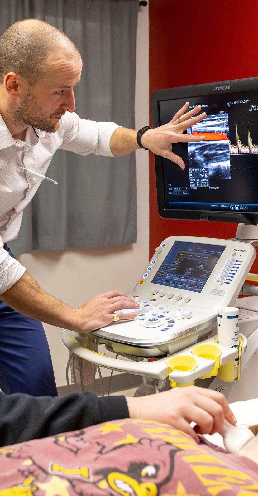 A researcher studies readings on equipment in a human performance lab.
