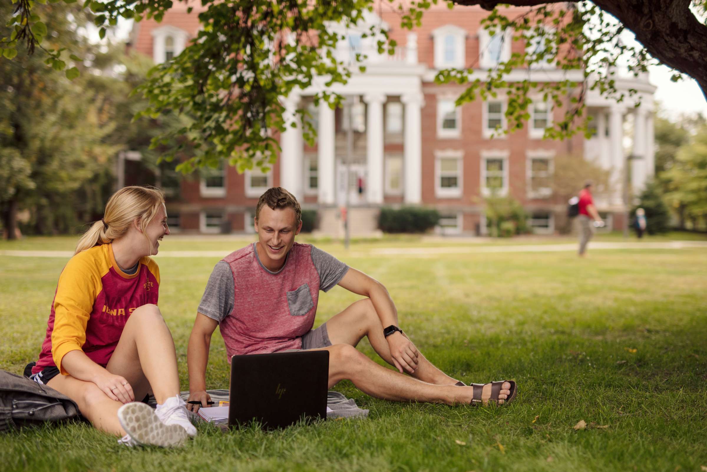 Two students looking at laptop on campus.