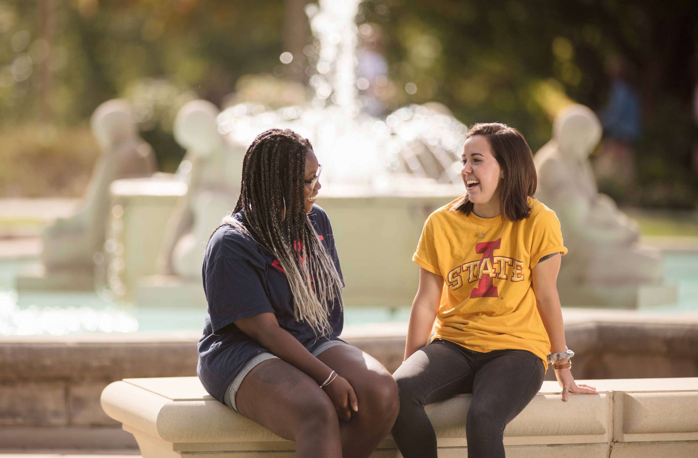 Two students sitting by the Fountain of the Four Seasons